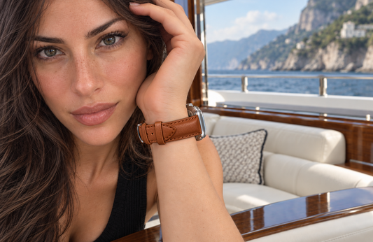 Woman wearing a padded WsC Defiant light brown leather Apple Watch strap aboard a yacht, with standard non-diamond silver hardware.